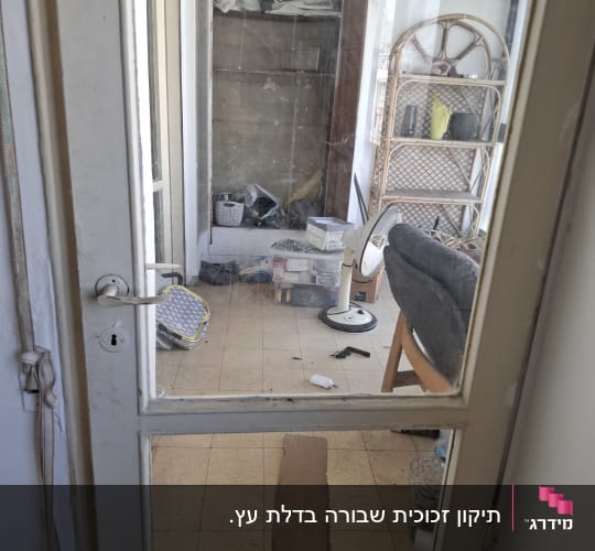 דלת זכוכית עם חדר מבולגן מאחוריה